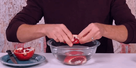 how to clean a pomegranate: disassemble pomegranate under water on grains